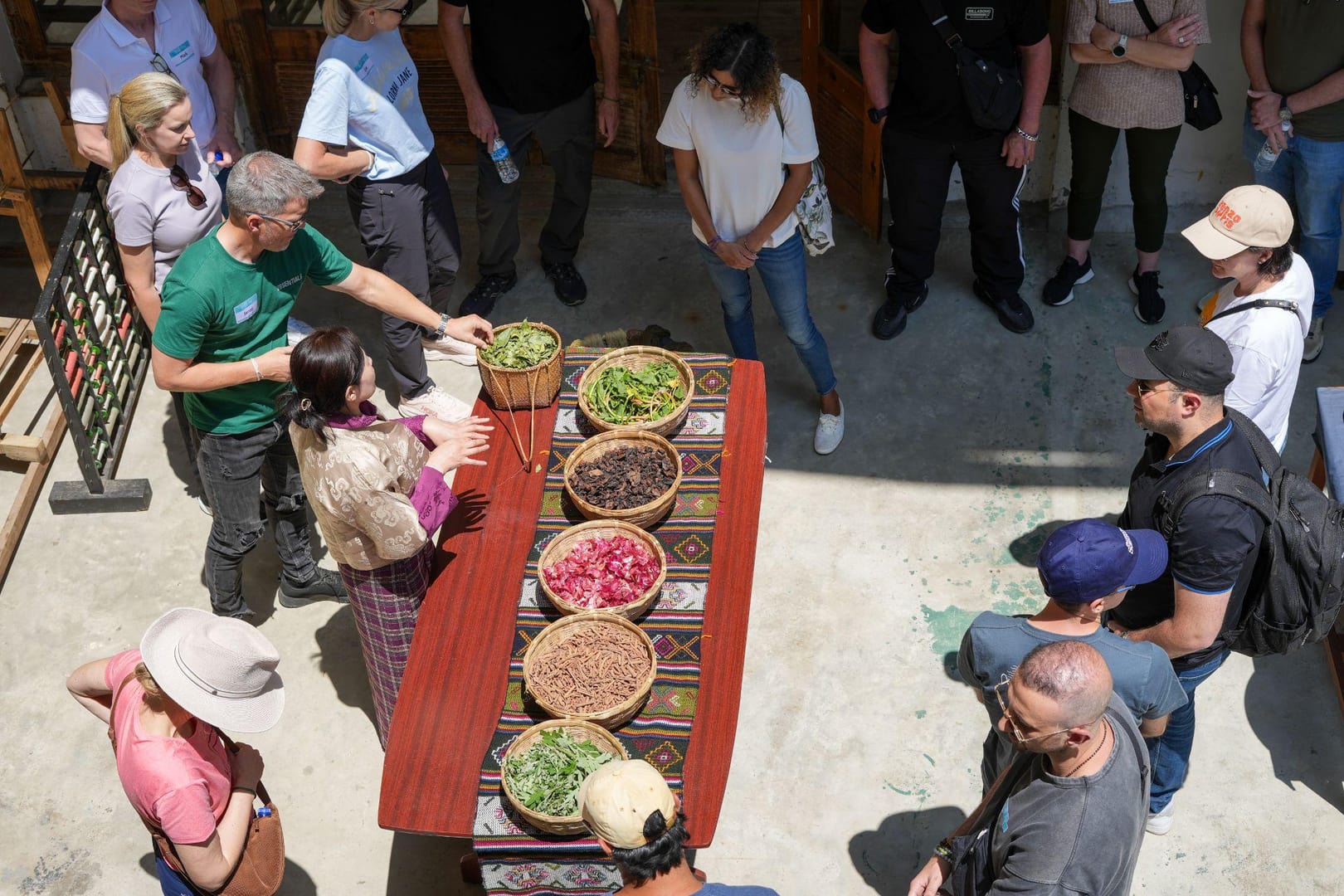 MICE group participants gathered around natural dye ingredients during a cultural workshop in Bhutan